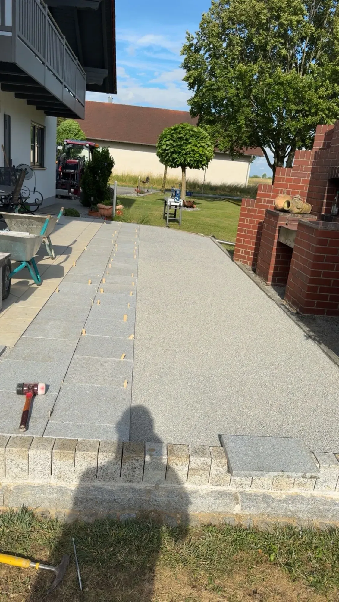 Fertig gepflasterte Terrasse aus Granit mit gesetzter Randmauer